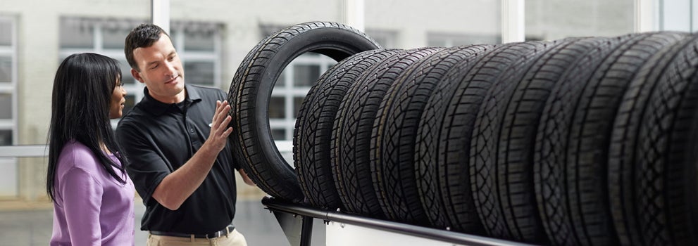 Subaru service representative showing customer a tire. | Wackerli Subaru in Idaho Falls ID