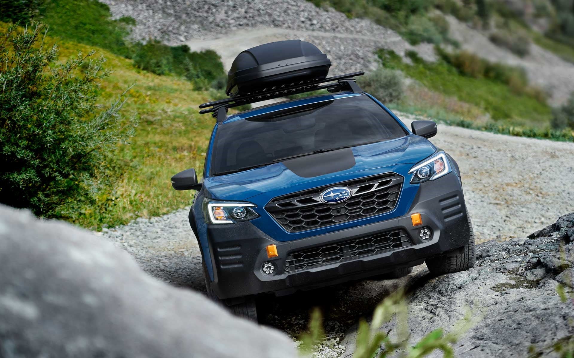 Subaru Outback Wilderness driving with roof cargo.