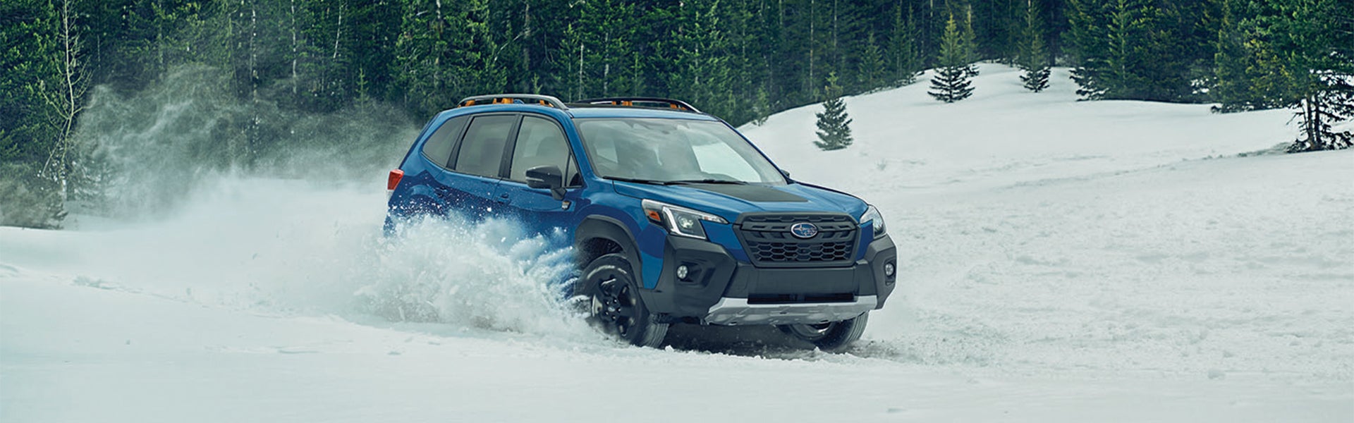 Subaru Forester driving through snow-covered terrain.