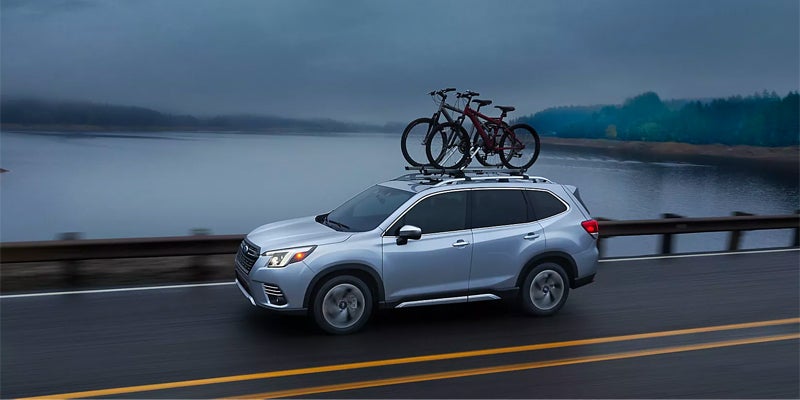 Subaru Forester driving with bicycles mounted on roof.
