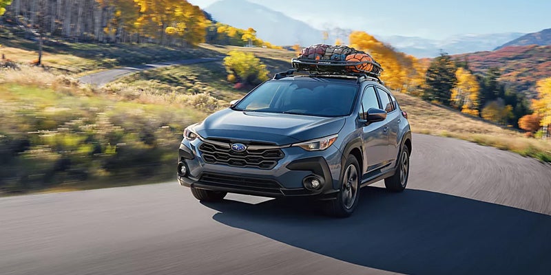 Subaru Crosstrek driving on scenic paved road.