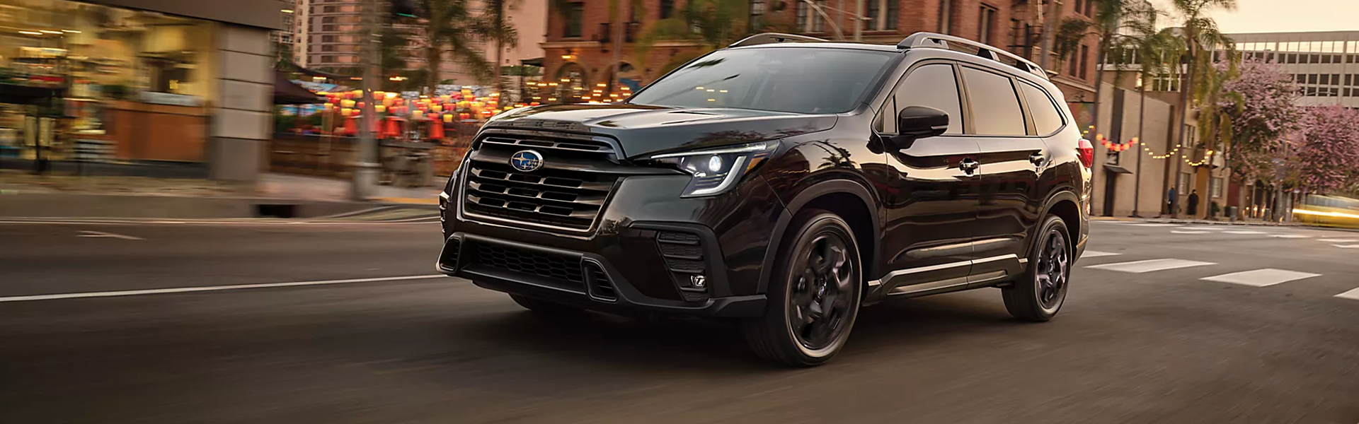 Black Subaru SUV with a bold front grille, LED headlights, roof rails, and black alloy wheels.